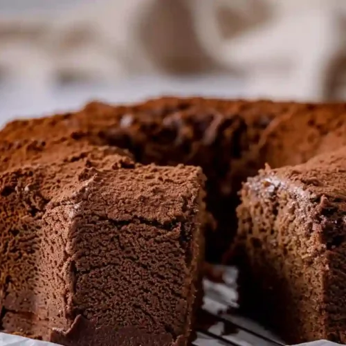 Close-up of a sliced chocolate chiffon cake on a white parchment paper