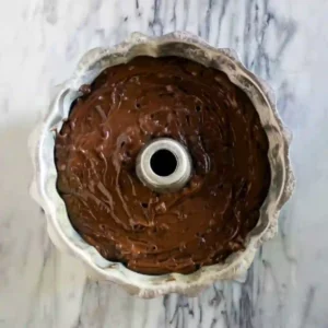 Batter with Chocolate Chips in Bundt Pan Chocolate peppermint bundt cake batter with chocolate chips poured evenly into a greased bundt pan