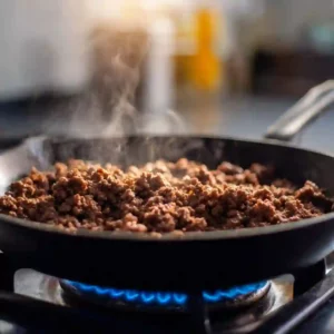 Ground beef browning in a skillet for Korean beef bowls