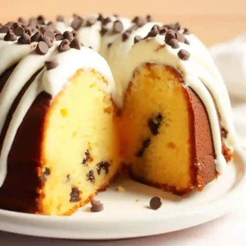 Slice of Nothing Bundt Cake Vanilla with Chocolate Chips Vertical photo of a slice of Nothing Bundt Cake Vanilla with chocolate chips and frosting on a plate