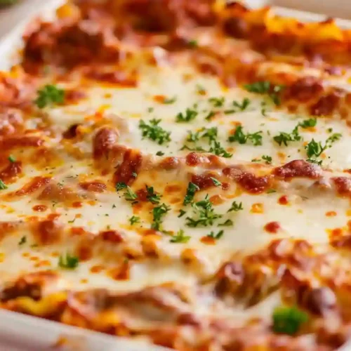 Best Beef Lasagna Recipe (Classic Italian Comfort Food) 8 Homemade beef lasagna baked with melted cheese and rich meat sauce in a white casserole dish.