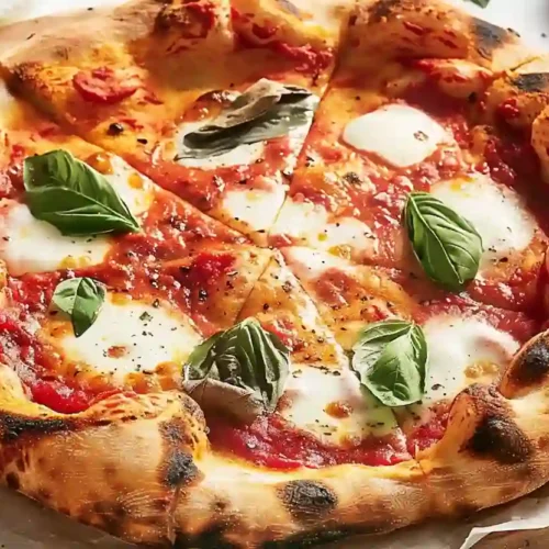 Close-up of homemade Neapolitan pizza with airy crust, tomato sauce, mozzarella, and basil on parchment paper.