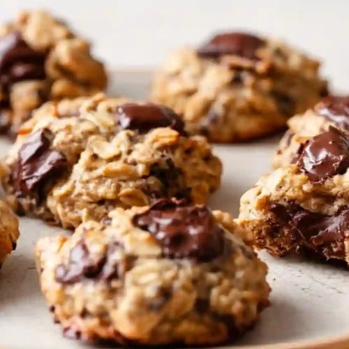 Close-up of homemade banana oatmeal cookies with melted chocolate chunks on a light background