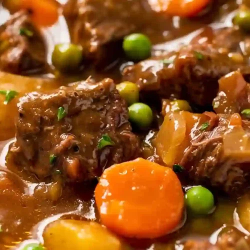 Beef Stew Crock Pot Recipes for Cozy Evenings 3 Vertical close-up image of crock pot beef stew with beef pieces, carrots, peas, and potatoes in rich gravy.