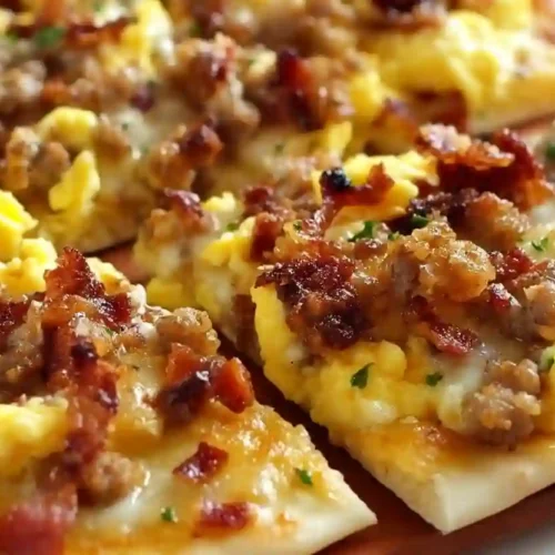 Breakfast Pizza for Cozy Mornings 3 Close-up of homemade breakfast pizza topped with scrambled eggs, sausage, bacon, and melted cheese
