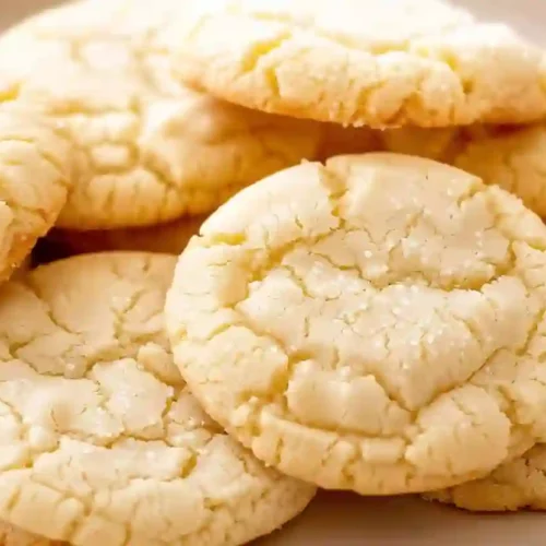 Close-up of homemade chewy sugar cookies with cracked tops on a plate