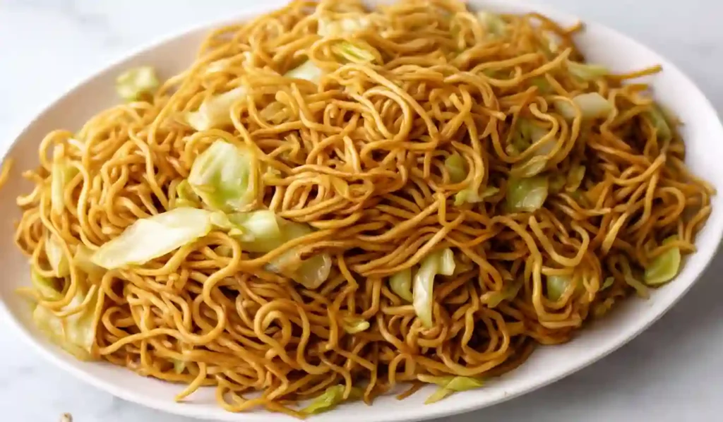 Close-up plate of authentic chow mein noodles with cabbage on a white dish