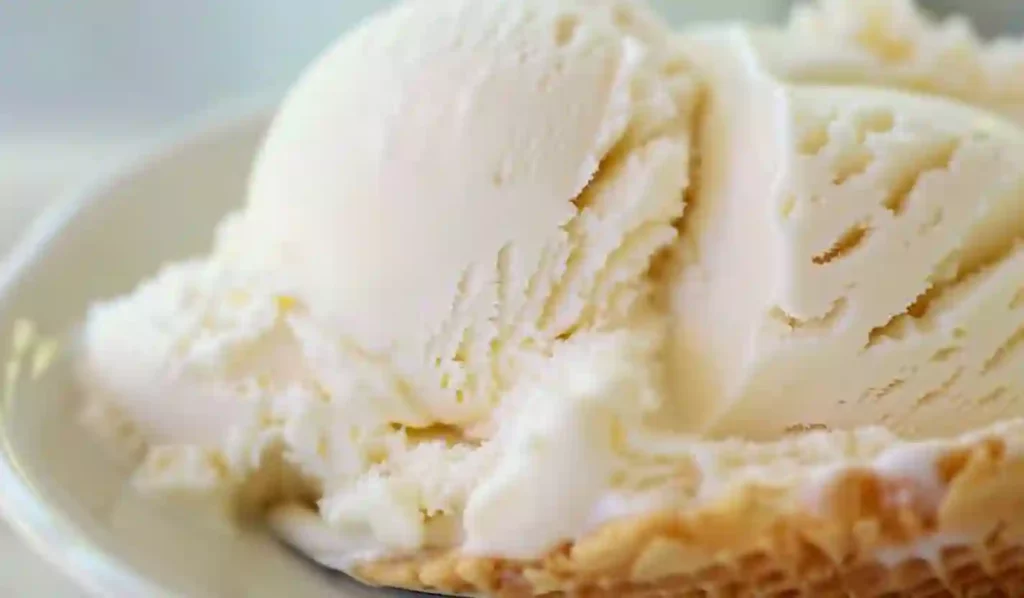 Close-up scoop of creamy homemade vanilla ice cream on a plate.