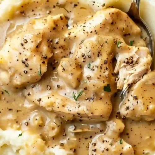 Creamy chicken and gravy served over mashed potatoes in a rustic bowl