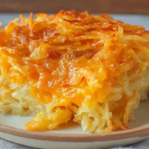 Extra close-up of Cracker Barrel hashbrown casserole with melted cheddar cheese and creamy shredded potatoes