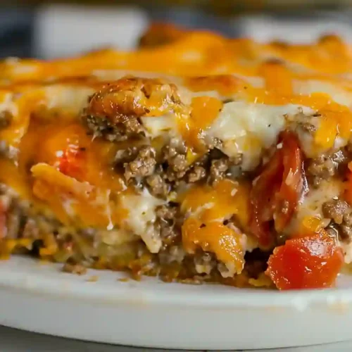 John Wayne Casserole – A Cozy, Protein-Packed Family Dinner Favorite 3 Extra close-up of John Wayne casserole with ground beef, cheddar cheese, tomatoes, and biscuit crust on a plate