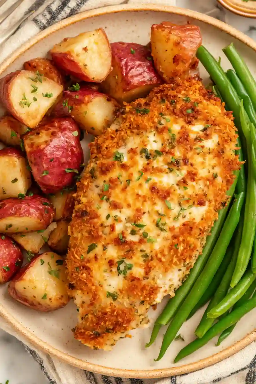 Parmesan Crusted Chicken with Roasted Potatoes and Green Beans 2 Vertical image of parmesan crusted chicken with roasted potatoes and green beans on a ceramic plate