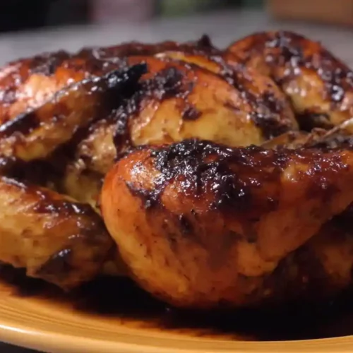 Extra close-up of Port-A-Pit style grilled chicken with glossy barbecue glaze served on a colored plate