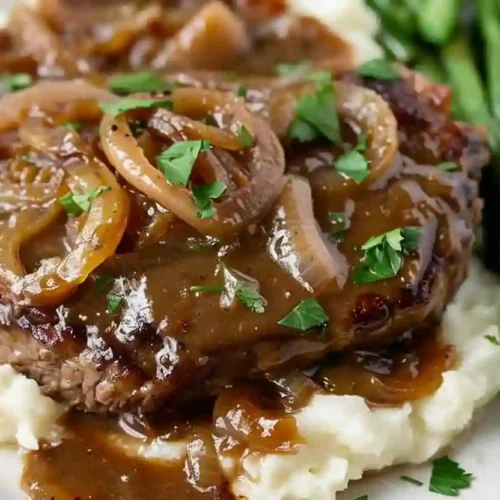 Beef cube steak covered in onion gravy served over mashed potatoes with green beans