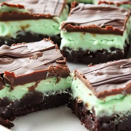 Close-up of mint brownies with chocolate ganache and green mint layer on white background