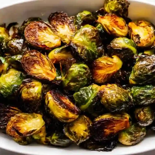 Roasted Brussels Sprouts for a Cozy, Healthy Family Dinner 3 Extra close-up of crispy roasted Brussels sprouts with caramelized edges in a white ceramic baking dish
