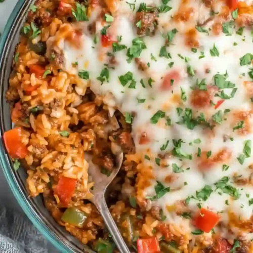 Extra close-up of cheesy stuffed pepper casserole with rice, ground meat, tomatoes, and melted mozzarella, garnished with fresh parsley
