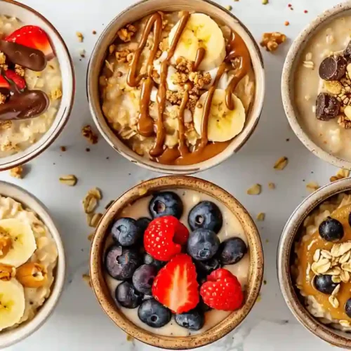6 Healthy Oatmeal Bowls for Cozy, Nourishing Mornings 3 Assortment of six healthy oatmeal bowls with fruit, nuts, peanut butter and chocolate drizzle on a marble kitchen surface