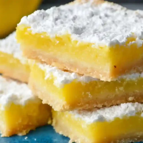 Perfect Dessert Lemon Bars – A Cozy Homemade Treat with Bright Citrus Comfort 3 Close-up of stacked lemon bars with powdered sugar on a blue plate