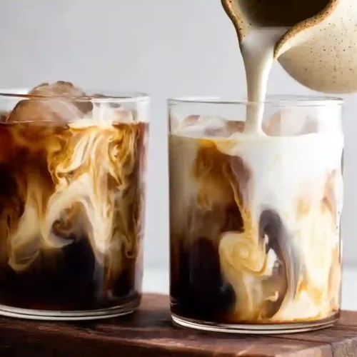 Smooth Homemade Cold Brew Coffee for Cozy Morning Energy 3 Cold brew coffee with cream being poured creating marble swirl in two clear glasses