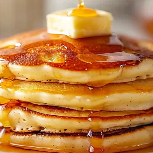 Cozy High-Protein Cottage Cheese Pancakes for Easy Homemade Mornings 3 Stack of golden cottage cheese pancakes topped with butter and maple syrup