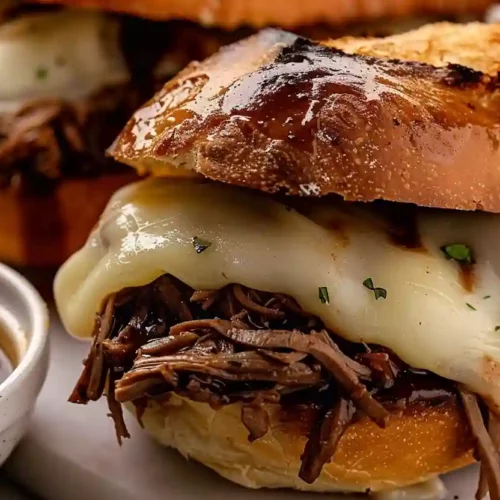Crockpot French Dip Sandwiches – Cozy Slow Cooker Comfort for Easy Family Dinners 3 Crockpot French dip sandwich with shredded beef and melted provolone on toasted bread served with au jus