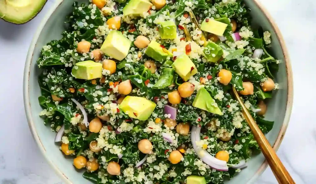 Kale quinoa salad with chickpeas, avocado, red onion and lemon dressing in a serving bowl