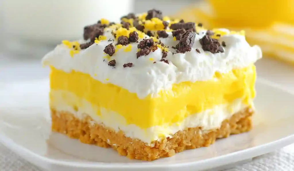 Close-up of layered lemon Oreo dessert with creamy lemon filling, whipped topping, and Oreo crust