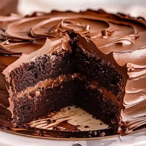 Matilda’s Chocolate Cake – A Cozy, Decadent Homemade Comfort Dessert 3 Matilda chocolate cake with a slice removed and thick glossy chocolate frosting