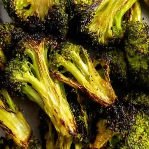 Roasted Broccoli Recipe for a Cozy, Nourishing Easy Dinner Side 3 Close-up of roasted broccoli florets with crispy charred edges on a neutral surface