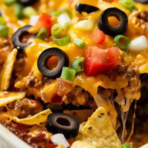 Taco Casserole – A Cozy Weeknight Comfort Food the Whole Family Loves 3 Cheesy taco casserole with ground beef, melted cheese, tortilla chips, black olives, tomatoes, and green onions in a baking dish