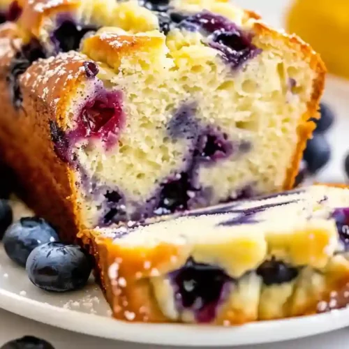 Close-up of sliced lemon blueberry loaf with juicy blueberries and moist texture
