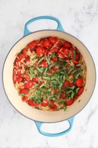 Caprese Orzo 9 Dry orzo, fresh basil, vegetable broth, and tomatoes combined in a Dutch oven before simmering.