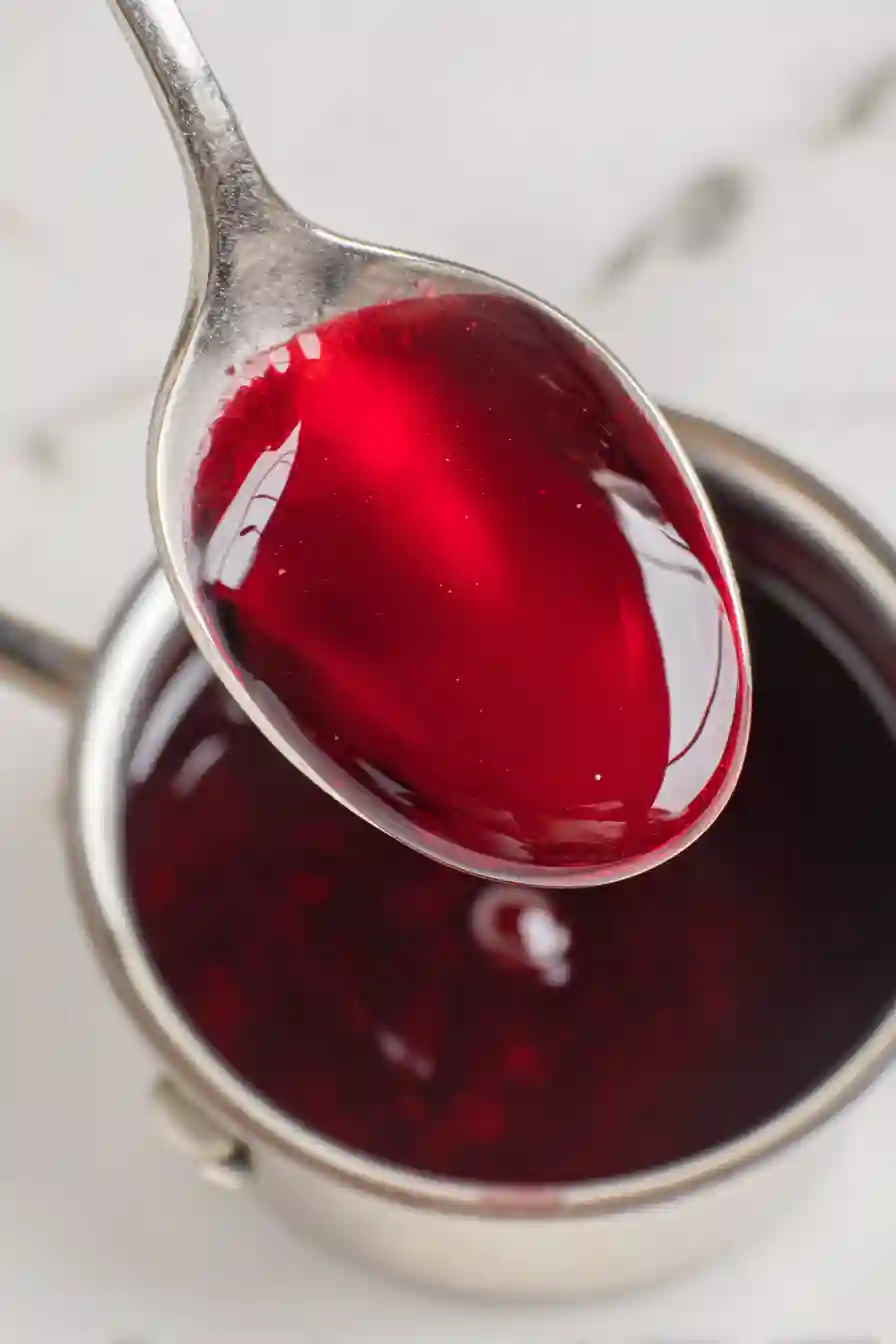 Greek Yogurt with Cherry Spoon Sweets 6 Glossy cherry syrup lightly coating a silver spoon while remaining smooth and pourable.