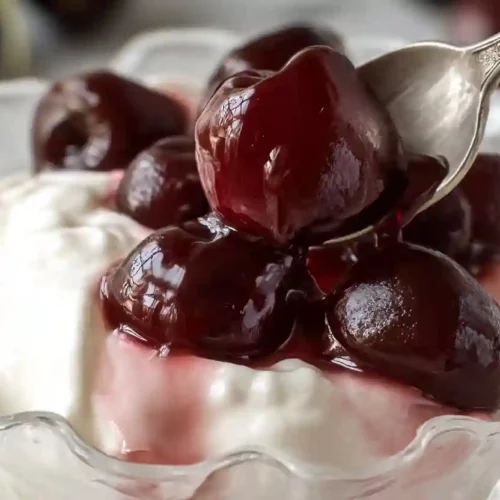 Greek Yogurt with Cherry Spoon Sweets 9 Creamy Greek yogurt topped with glossy cherry spoon sweets in a clear glass dessert bowl.
